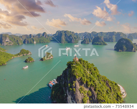 Aerial view panorama of floating fishing village and rock island, Halong Bay, Vietnam, Southeast Asia. UNESCO World Heritage Site. Junk boat cruise to Ha Long Bay. Popular landmark of Vietnam 73548934