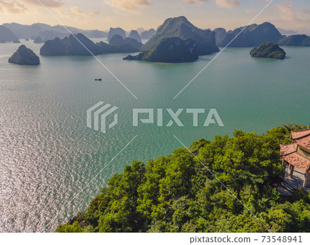 Aerial view panorama of floating fishing village and rock island, Halong Bay, Vietnam, Southeast Asia. UNESCO World Heritage Site. Junk boat cruise to Ha Long Bay. Popular landmark of Vietnam 73548941