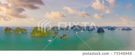 Aerial view panorama of floating fishing village and rock island, Halong Bay, Vietnam, Southeast Asia. UNESCO World Heritage Site. Junk boat cruise to Ha Long Bay. Popular landmark of Vietnam Aerial view panorama of floating fishing village and rock island, Halong Bay, Vietnam, Southeast Asia. UNESCO World Heritage Site. Junk boat cruise to Ha Long Bay. Popular landmark of Vietnam 73548948