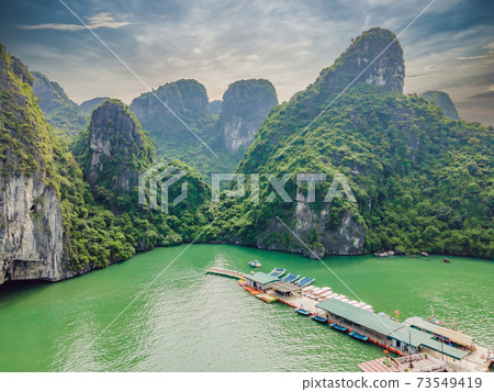 Aerial view panorama of floating fishing village and rock island, Halong Bay, Vietnam, Southeast Asia. UNESCO World Heritage Site. Junk boat cruise to Ha Long Bay. Popular landmark of Vietnam 73549419