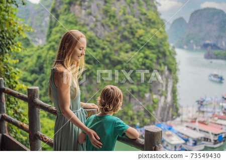Mom and son travelers in Halong Bay. Vietnam. Travel to Asia, happiness emotion, summer holiday concept. Picturesque sea landscape. Ha Long Bay, Vietnam. After coronavirus COVID 19 73549430