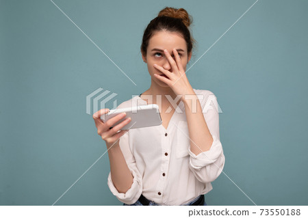 photo of attractive angry upset young blonde curly woman wearing casual white shirt isolated over 73550188