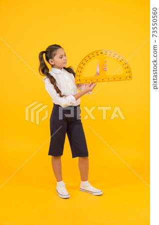 Setting square with protractor. Little girl using triangle Setting square with protractor. Little girl using triangle 73550560