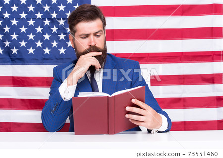 Hipster man reading book USA flag background, study hard concept Hipster man reading book USA flag background, study hard concept 73551460