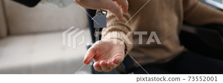 Female hand hold give key with keychain from new house and give to desabled. Female hand hold give key with keychain from new house and give to desabled. 73552001