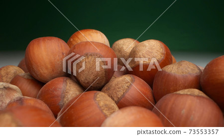 extremely close-up, detailed. many hazelnuts on a dark background 73553357