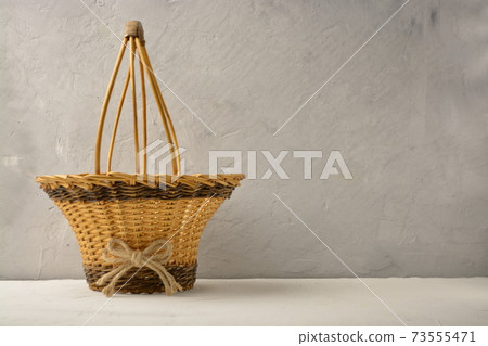 braided basket on a gray textured background 73555471