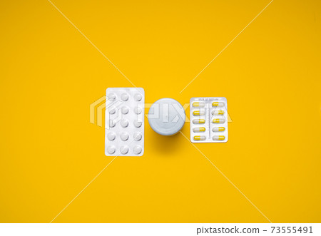 Medical capsules, pills on a yellow background. Medical capsules, pills on a yellow background. 73555491
