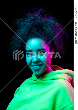 African-american woman's portrait isolated on dark studio background in multicolored neon light 73557558