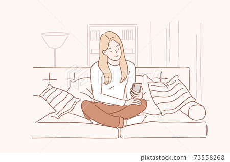 Young smiling attractive woman or girl using a smartphone writes or speaks at home. Concept of communication, comfort, smart. 73558268