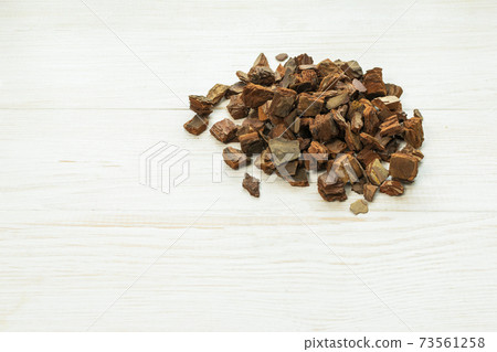Best soil for orchids, cut pine bark, prepared bark on wooden background Best soil for orchids, cut pine bark, prepared bark on wooden background 73561258