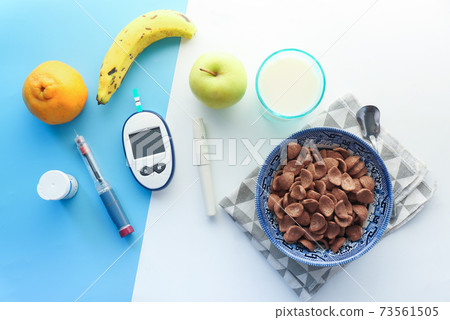 diabetic measurement tools , insulin pen, fruits and corn flakes on table  73561505