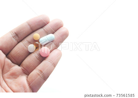 man's hand with pills and capsule isolated on white  73561585