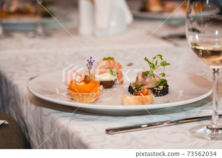 Served table for food and wine tasting. Snacks with shrimp, fish fillets, Spain tapas recipe food pintxos Served table for food and wine tasting. Snacks with shrimp, fish fillets, Spain tapas recipe food pintxos 73562034