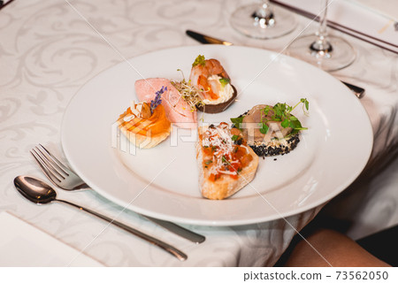 Served table for food and wine tasting. Snacks with shrimp, fish fillets, Spain tapas recipe food pintxos Served table for food and wine tasting. Snacks with shrimp, fish fillets, Spain tapas recipe food pintxos 73562050