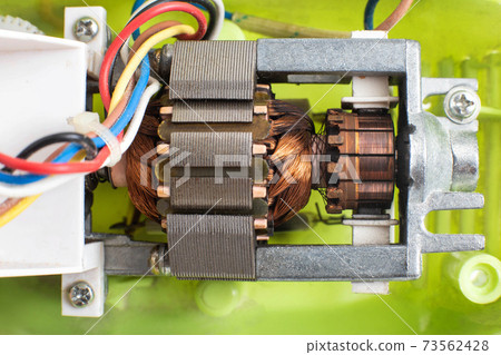 Broken electric motor in a household appliance hand mixer. Malfunction of the rotor and stator of electrical components, close-up 73562428