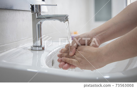 Men are washing their hands in the sinks to clear respiratory bacteria and viruses, sanitation and reduce the spread of COVID-19 that is spread around the world, Hygiene ,Sanitation concept. Men are washing their hands in the sinks to clear respiratory bacteria and viruses, sanitation and reduce the spread of COVID-19 that is spread around the world, Hygiene ,Sanitation concept. 73563008