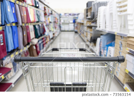 Shopping cart in supermarket, Abstract blurred photo in shopping malls, Cart in the market, wide variety of products are placed on the shelves for an orderly display. 73563154