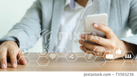 Business man wear purple shirt using mobile phone for digital online marketing on office desk. Business  finance technology concept.icon online e-commerce global market shopping,banking and payments. 73563236