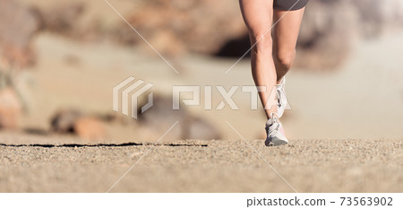 Running shoe closeup of woman running on gravel path with sports shoes 73563902