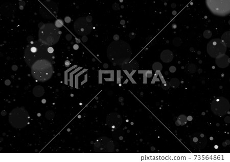 Bokeh of white snow on a black background. Snowfall - design element. 73564861