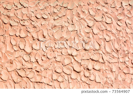 The concrete surface is painted with a pink cracked paint. 73564907