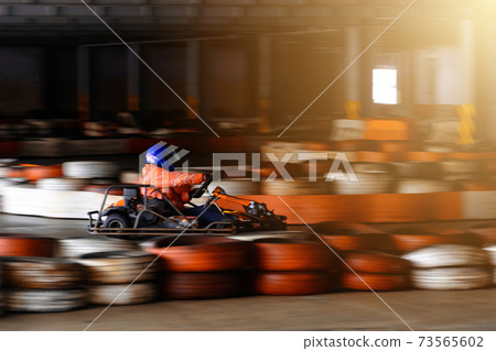 Dynamic karting competition at speed with blurry motion on an equipped racecourse 73565602