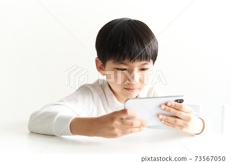 Elementary school students who hold their smartphones sideways and enjoy videos / games Elementary school students who hold their smartphones sideways and enjoy videos / games 73567050