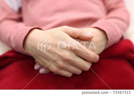 Women's hands are folded together. Feminine serenity and self-confidence 73567315