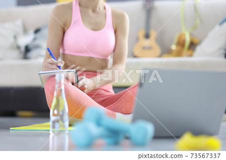 Woman makes home workout plan in diary 73567337