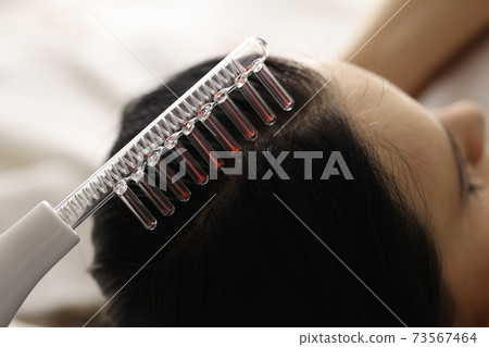 Woman is doing hair strengthening procedures closeup Woman is doing hair strengthening procedures closeup 73567464