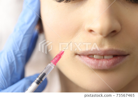 Beautician gives woman an injection in face Beautician gives woman an injection in face 73567465
