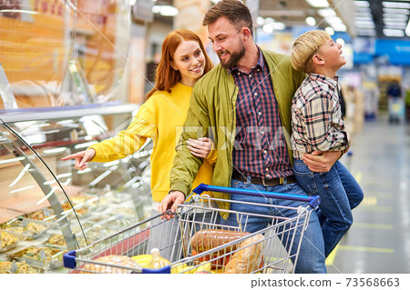 cheerful couple, parents with restless son in grocery store 73568663