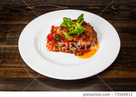 Juicy piece of meat with stewed vegetables 73568912