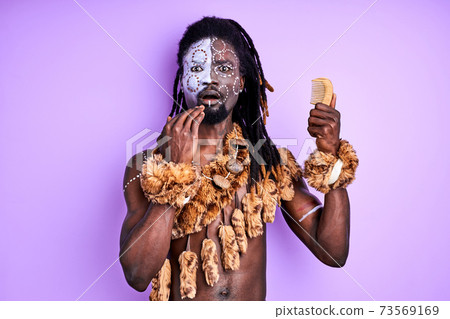 shocked tribal primitive male looks at comb 73569169