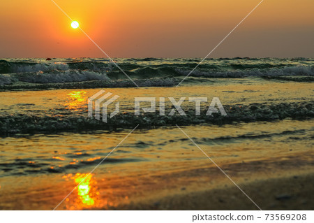 Wet sea sand on beach against background beautiful golden sunset. Close up sea sand on shore ocean during sunset.Landscape sunset sea coast. Golden wet sand sand on beach on a sunset background. Wet sea sand on beach against background beautiful golden sunset. Close up sea sand on shore ocean during sunset.Landscape sunset sea coast. Golden wet sand sand on beach on a sunset background. 73569208