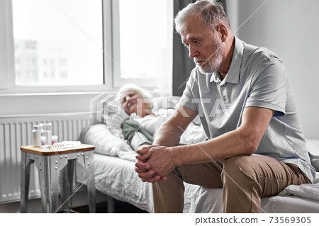 upset pensioner man sits in depression while her sick woman suffering from covid-19 upset pensioner man sits in depression while her sick woman suffering from covid-19 73569305