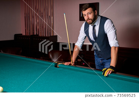 portrait of caucasian male standing next to billiards table portrait of caucasian male standing next to billiards table 73569525