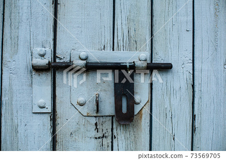 A wooden fence, a door. White boards 73569705