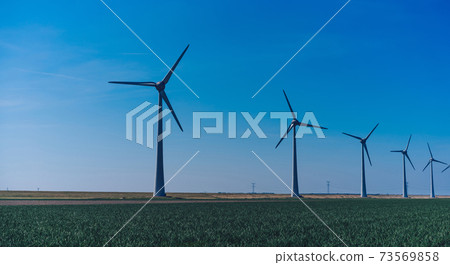Modern windmills on rural landscape area under blue sky Modern windmills on rural landscape area under blue sky 73569858