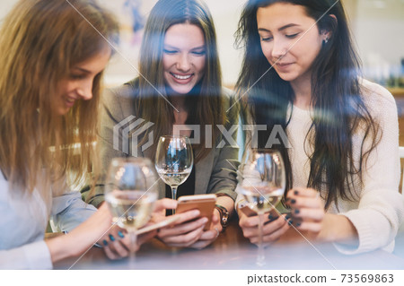 Three female friends enjoying meeting in cozy cafe Three female friends enjoying meeting in cozy cafe 73569863