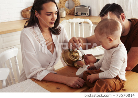 young family with little cute son on kitchen in morning happy smiling, lifestyle people concept 73570814