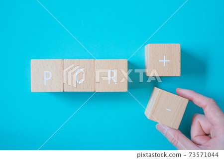 Negative PCR test result | Blocks with "PCR", "+" and "-" and hands to pinch them 73571044