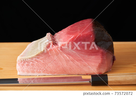 Tuna block on a cutting board Tuna block on a cutting board 73572072