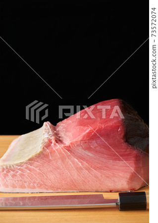 Tuna block on a cutting board Tuna block on a cutting board 73572074