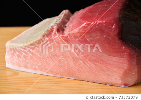 Tuna block on a cutting board Tuna block on a cutting board 73572079