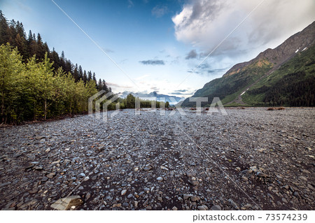 Mountains river creek valley with no water in Alaska at sunset time 73574239
