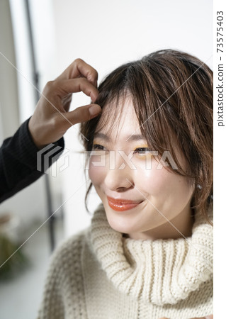 A woman having her hair done 73575403