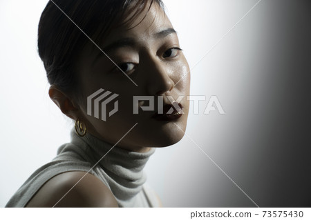 Dramatic female portrait in light and shadow Dramatic female portrait in light and shadow 73575430