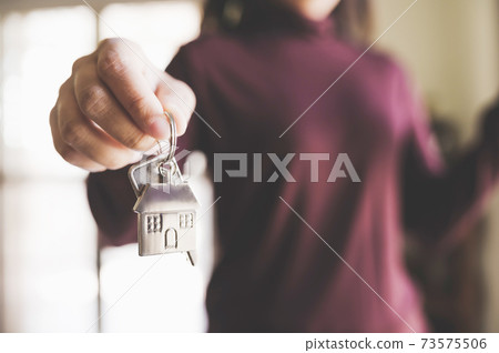 Woman holding keychains house key Woman holding keychains house key 73575506